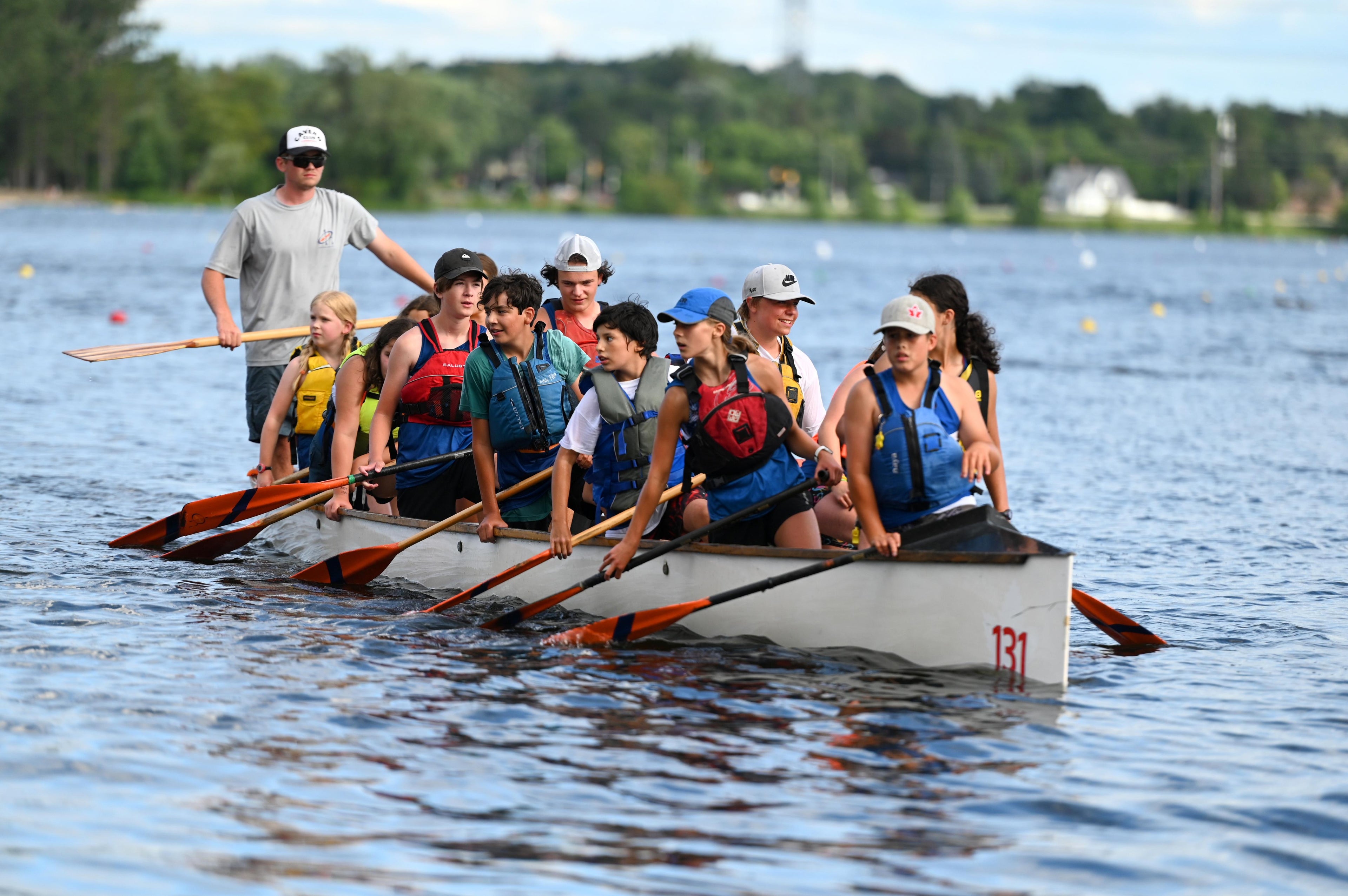 Athletes bring the boat back to dock after a war canoe race with Ethan coxing the crew.