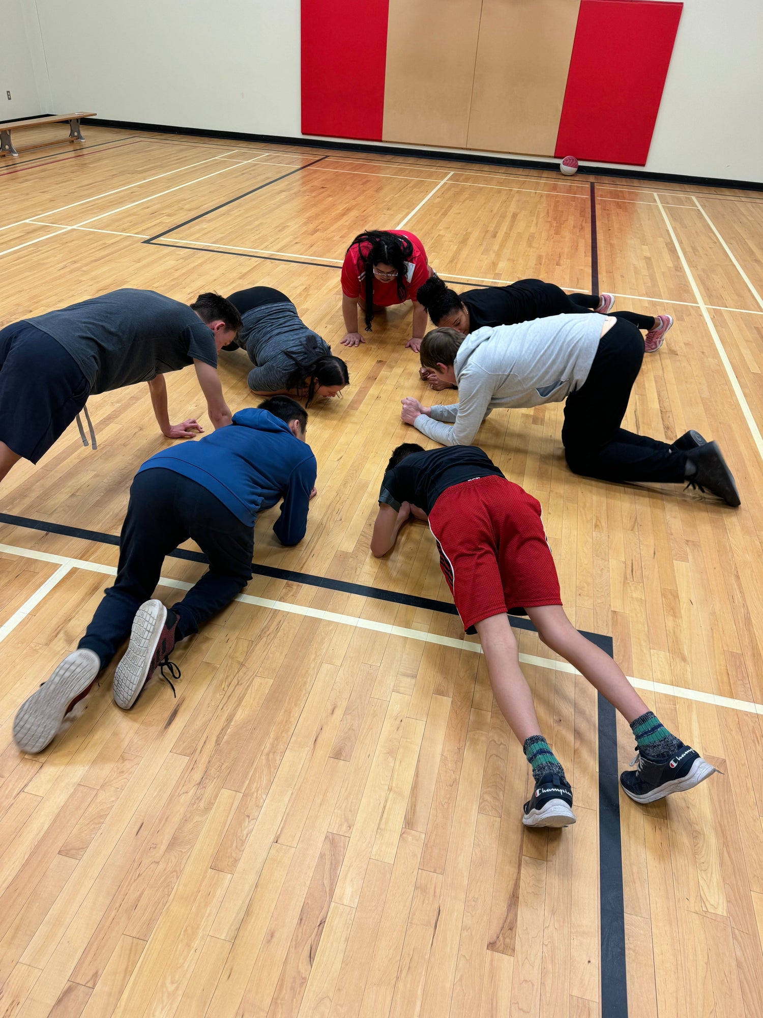 SO athletes holding a plank position on the floor of a school gym while doing winter training.