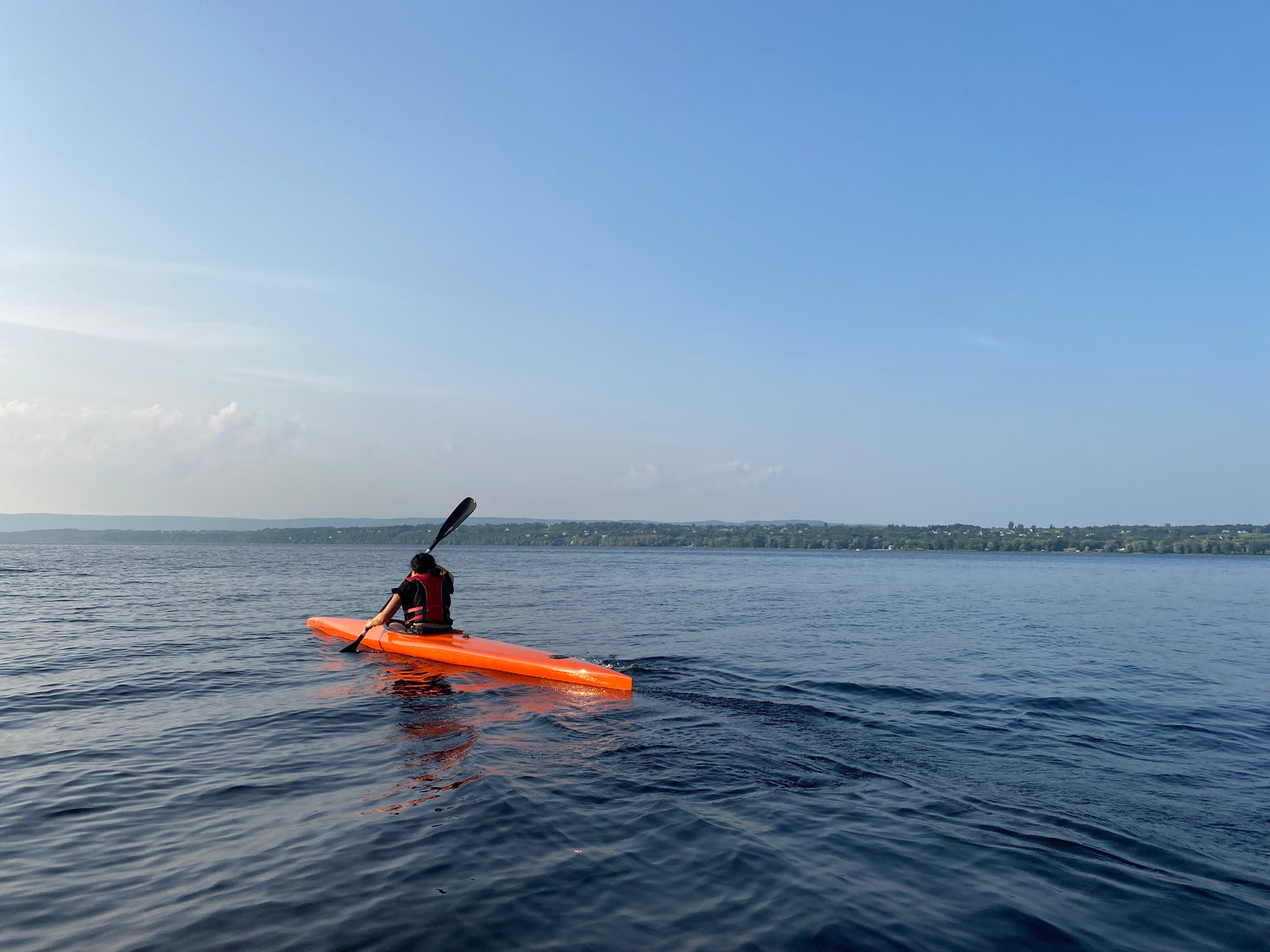 AFP participant paddles an orange K1 with beautiful sunset lighting